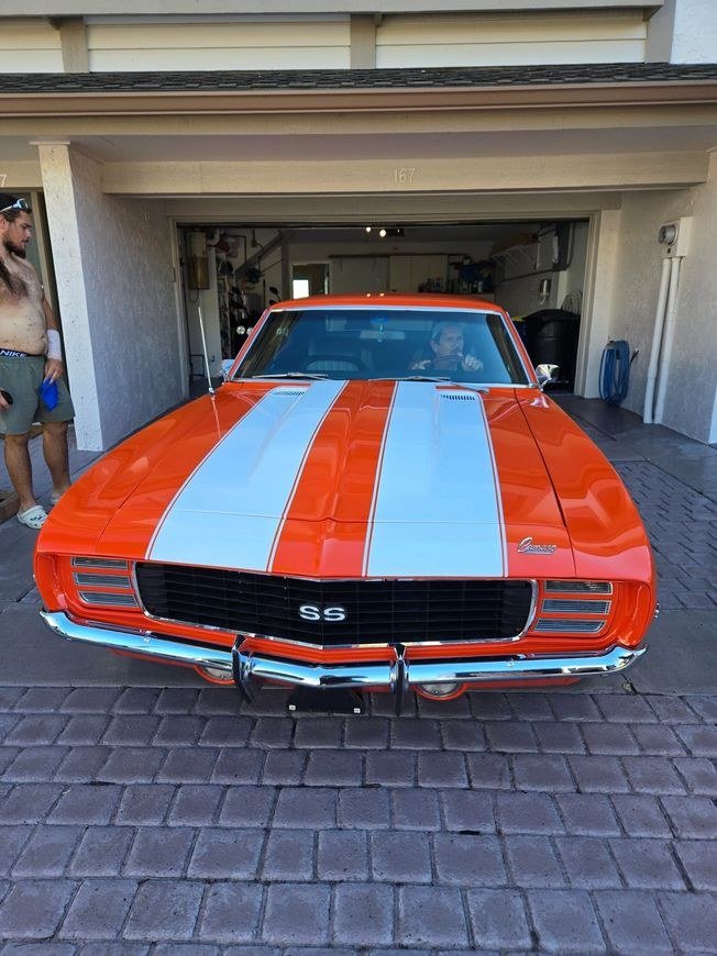 An orange and white striped Camaro SS in a garage
