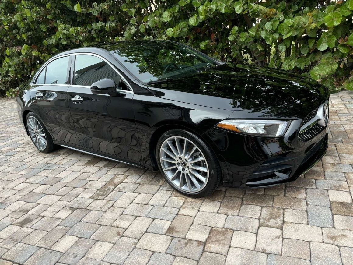 A black Mercedes saloon on brick paving