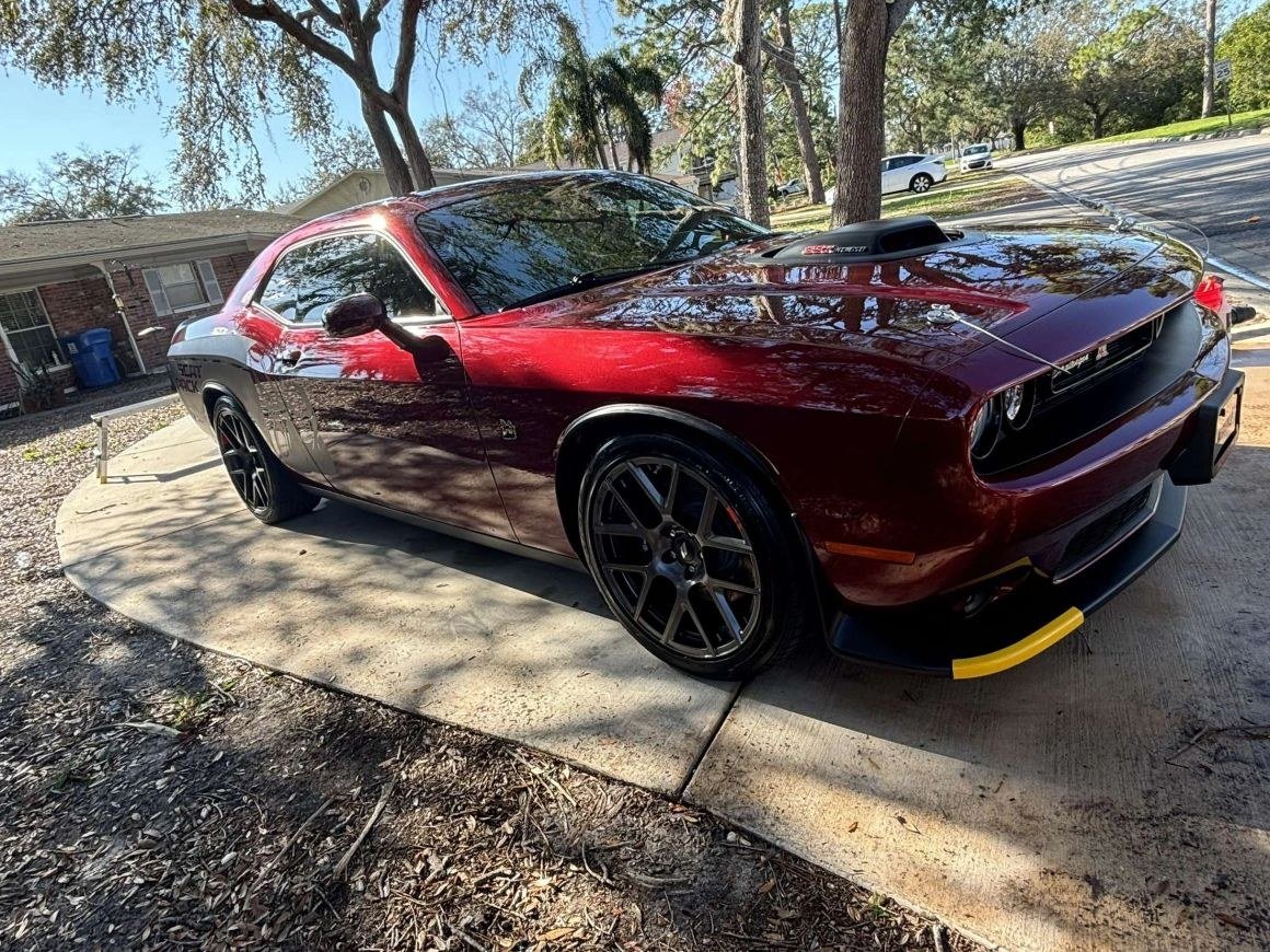 A dark red Dodge Challenger on a driveway